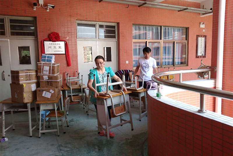 南宫28志愿者及家长用消毒液擦拭桌椅